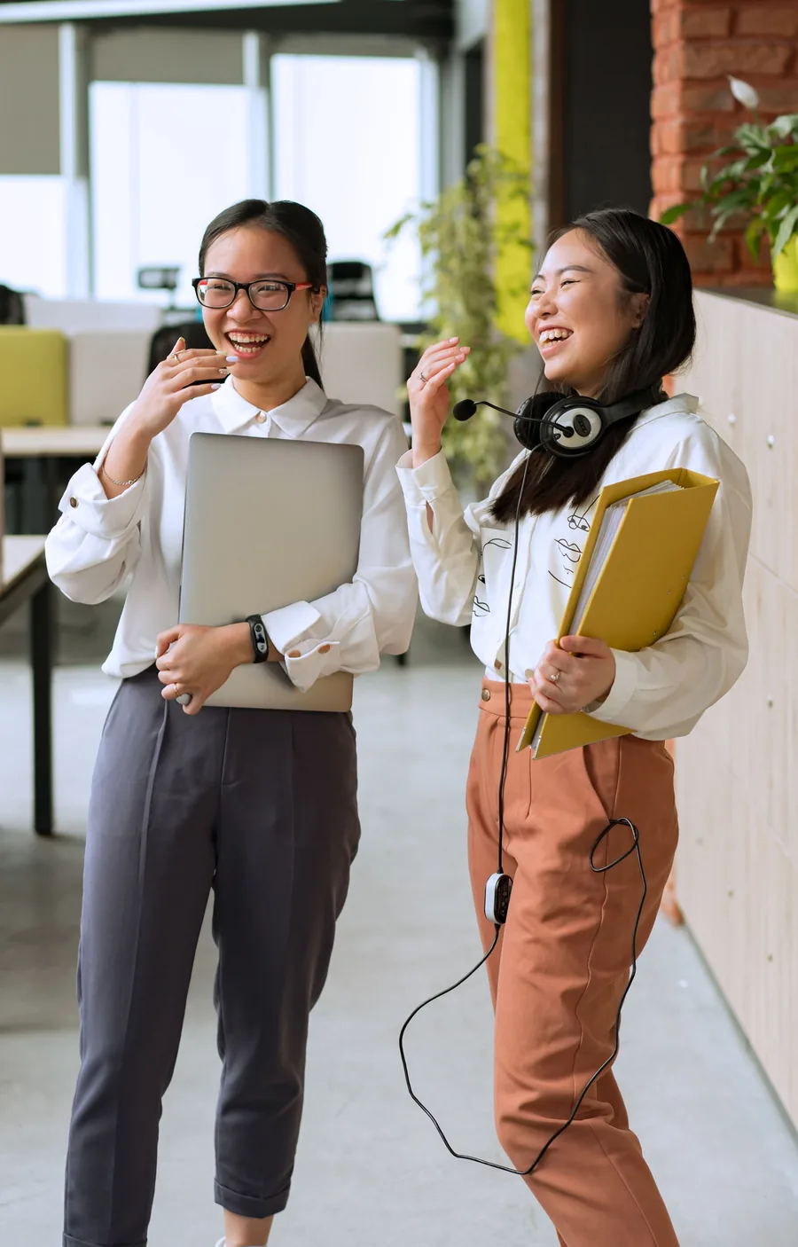 ヘッドセットやノートPCを手に、笑顔で並ぶmtsの女性スタッフ2人